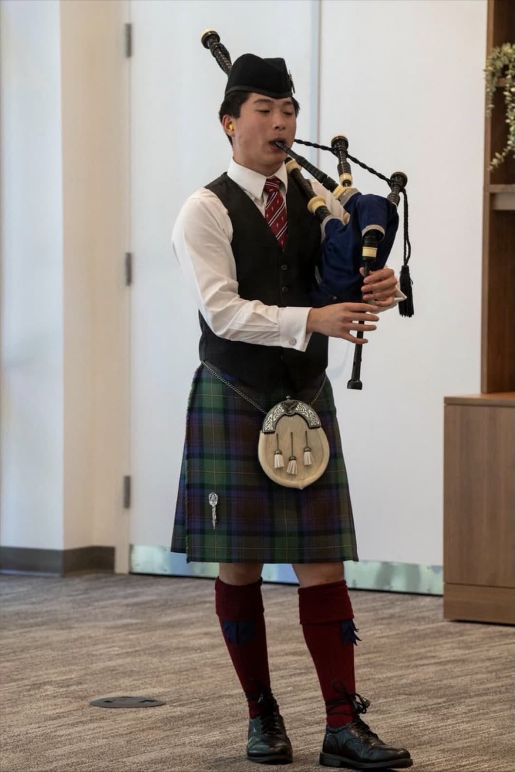 A Pipes for the People instructor performing in full highland dress